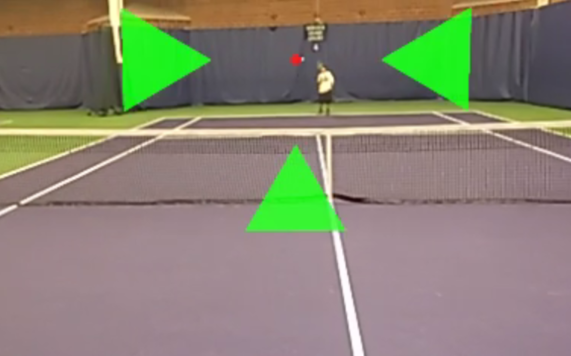 A first-person point-of-view image of a low vision person playing tennis while using ARTennis. The tennis ball is covered by a red dot, while four green arrows point towards the ball, forming a crosshair.